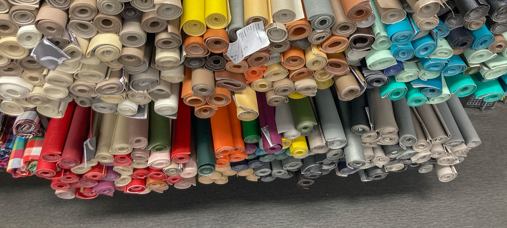 Ein Gestell voller farbige Stoffrollen